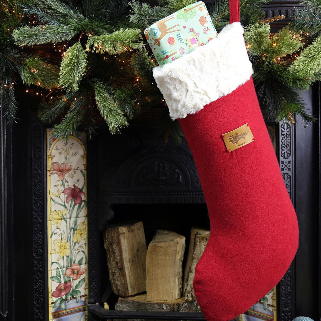 Big Christmas stocking hanging on the fireplace filled with present